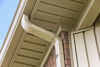 Gutter and Downspout Near the Roof of a House